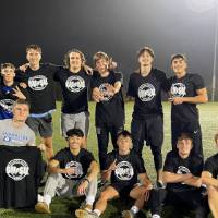 Students wearing championship shirts from a men's flag football tournament